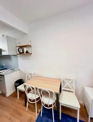 a kitchen with a wooden table and two chairs at Beaumont Résidence in Nice