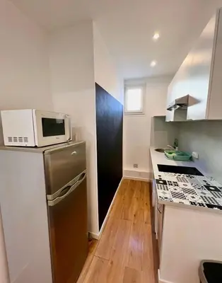 a kitchen with a stainless steel refrigerator and a microwave at Beaumont Résidence in Nice