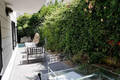 a patio with a bench and a bush at Luxury villa with Pool and Garden perfect location in Beaulieu-sur-Mer