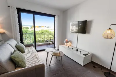 a living room with a couch and a large window at Le Galion - City centre - Bright - AC - Parking in Cagnes-sur-Mer