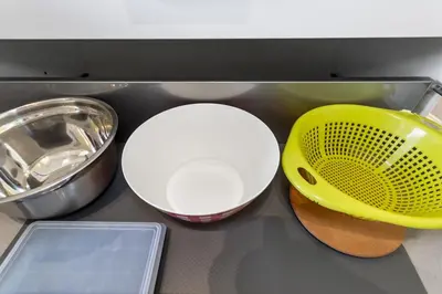 a kitchen counter with two dishes and a yellow strainer at Le Galion - City centre - Bright - AC - Parking in Cagnes-sur-Mer