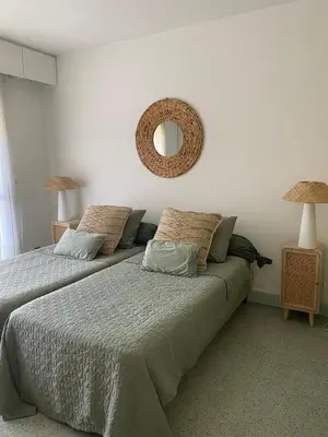 a bedroom with two beds and a mirror on the wall at Centre ville de St Jean Cap Ferrat in Saint-Jean-Cap-Ferrat