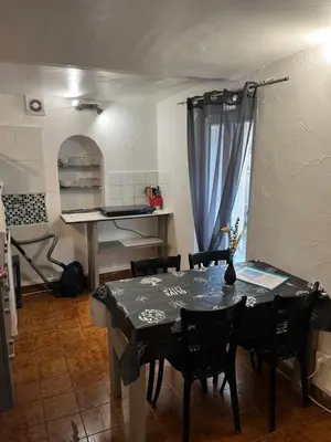 a dining room with a table and chairs and a kitchen at appartement entresol nice 1,2 kilomètre de la plage mer promenade in Nice