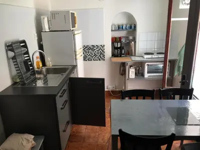 a kitchen with a sink and a table with chairs at appartement entresol nice 1,2 kilomètre de la plage mer promenade in Nice