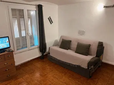 a living room with a couch and a window at appartement entresol nice 1,2 kilomètre de la plage mer promenade in Nice