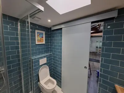 a bathroom with a toilet and blue tiles at Charmant studio rénové – Place de la République in Villefranche-sur-Mer