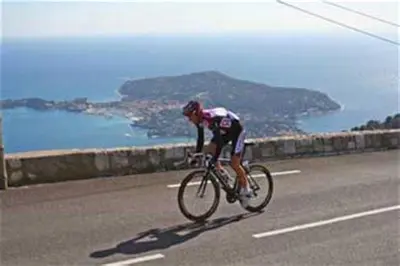 a man riding a bike down a road at 1 chambre chez l'habitant, vue mer, ville et plage in Nice