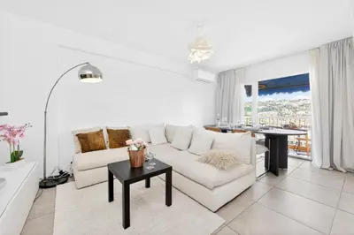 a white living room with a white couch and a table at Spacieux 4 pièces - Balcon - Parking - FC in Saint-Laurent-du-Var