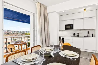 a kitchen and dining room with a table and chairs at Spacieux 4 pièces - Balcon - Parking - FC in Saint-Laurent-du-Var