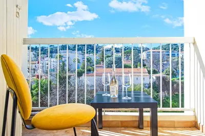 a table with wine glasses on a balcony at Spacieux 4 pièces - Balcon - Parking - FC in Saint-Laurent-du-Var