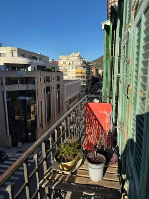 a balcony with potted plants on a city street at 3 pièces lumineuses, 3 nuitées minimum in Nice