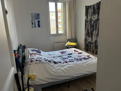 a small bedroom with a bed with a quilt on it at 3 pièces lumineuses, 3 nuitées minimum in Nice