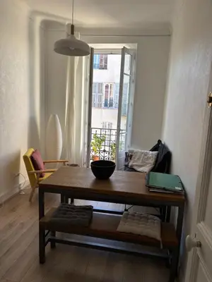 a room with a wooden table and a window at 3 pièces lumineuses, 3 nuitées minimum in Nice