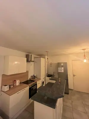 a kitchen with white cabinets and a black counter top at Le Riviera in Nice