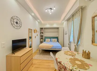 a bedroom with a bed and a table and a tv at Cherie in Nice in Nice