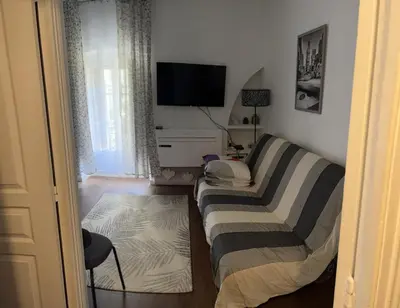a living room with two beds and a flat screen tv at Nice 2-room apartment off the beach in Nice