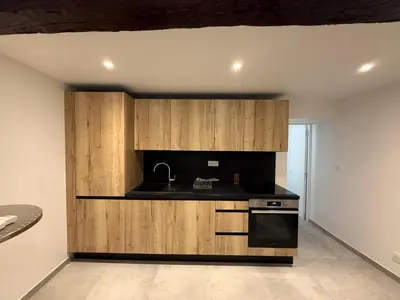 a kitchen with wooden cabinets and a sink at Bel appartement proche de la mer et de la gare La Mascotte in Beaulieu-sur-Mer