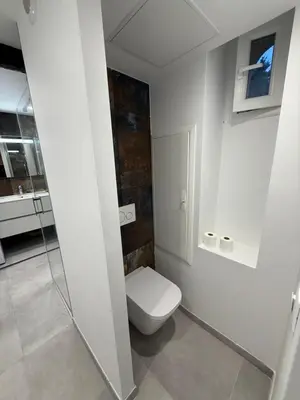 a white bathroom with a toilet and a sink at Bel appartement proche de la mer et de la gare La Mascotte in Beaulieu-sur-Mer
