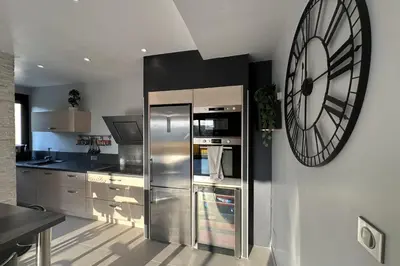 a kitchen with a large clock on the wall at Spacious apartment in Nice with balcony in Nice
