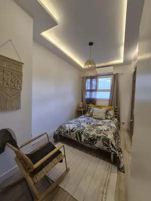 a bedroom with a bed and a chair and a window at petit appart cozy in Nice