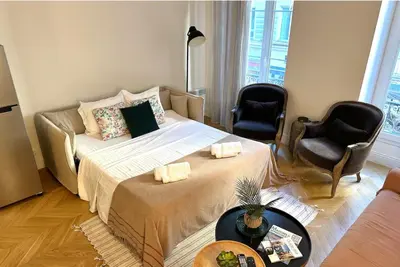 a living room with a bed and two chairs at Chic et élégant - au cœur du Carré d'Or in Nice