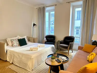 a living room with a bed and a couch at Chic et élégant - au cœur du Carré d'Or in Nice