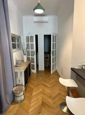 a living room with a wooden floor and white walls at Chic et élégant - au cœur du Carré d'Or in Nice