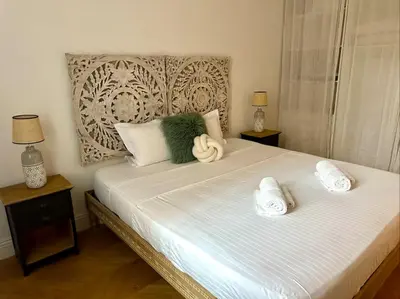 a bedroom with a large bed with towels on it at Chic et élégant - au cœur du Carré d'Or in Nice