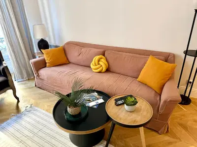 a living room with a brown couch and two tables at Chic et élégant - au cœur du Carré d'Or in Nice
