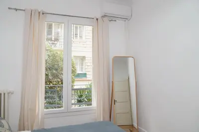 a bedroom with a mirror and a window at Fantastic Centra Peaceful Location in Nice