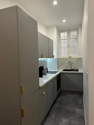a kitchen with white cabinets and a sink at Luxueux Logement à 2 pas de la mer, Vieille ville in Nice