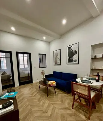 a living room with a blue couch and a table at Luxueux Logement à 2 pas de la mer, Vieille ville in Nice