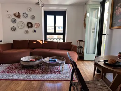 a living room with a brown couch and a table at L'âme de Nice - Terrasse dorée sur Place Masséna in Nice