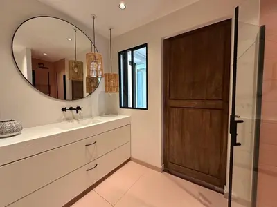 a bathroom with a wooden door and a mirror at L'âme de Nice - Terrasse dorée sur Place Masséna in Nice
