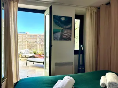 a bedroom with a bed and a view of a patio at L'âme de Nice - Terrasse dorée sur Place Masséna in Nice