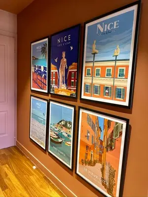 a group of pictures hanging on a wall at L'âme de Nice - Terrasse dorée sur Place Masséna in Nice
