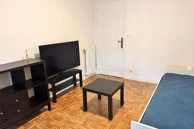 a living room with a bed and a tv and a table at Studio with veranda 5min walk to the beach in Nice