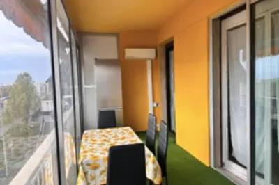 a room with a balcony with a table and a window at Studio with veranda 5min walk to the beach in Nice