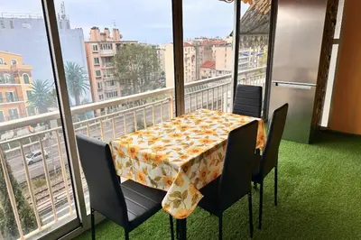 a table and chairs in a balcony with a view of a city at Studio with veranda 5min walk to the beach in Nice