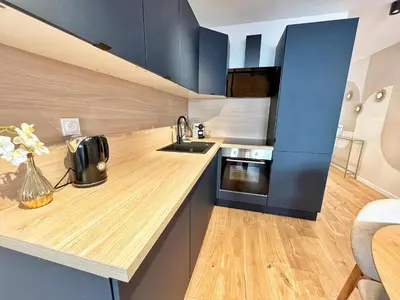 a kitchen with blue cabinets and a wooden counter top at Ref 127 - 3 Pièces 2 chambres Nice Port in Nice
