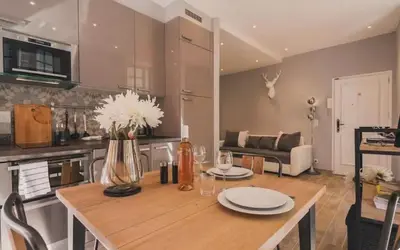 a kitchen and living room with a wooden table with flowers at Authentic Nice Old Town, separate bedroom, AC in Nice