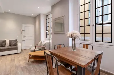 a living room with a wooden table and chairs at Authentic Nice Old Town, separate bedroom, AC in Nice