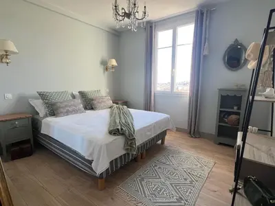 a bedroom with a bed and a chandelier at Golden hours luxury and panoramic view in Nice