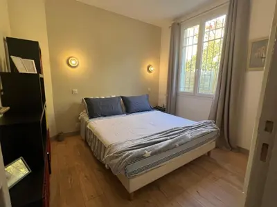 a bedroom with a bed with blue pillows and a window at Golden hours luxury and panoramic view in Nice