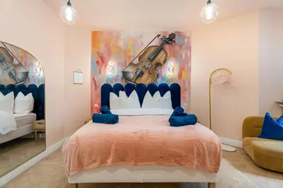 a bedroom with a large bed with a painting on the wall at Cocon stylé Centre et mer à pied CLIM WIFI in Nice