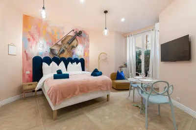 a bedroom with a guitar painting on the wall at Cocon stylé Centre et mer à pied CLIM WIFI in Nice