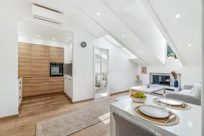 a kitchen and living room with white walls and a table at Charmant 2p au port de Nice - Calme et climatisé in Nice