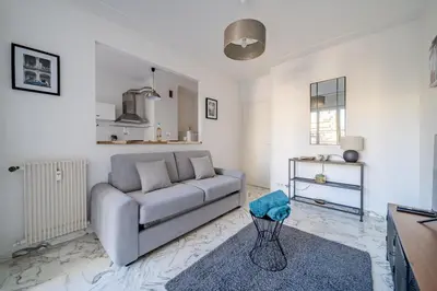 a living room with a couch and a table at Port de Nice - Studio with balcony in Nice