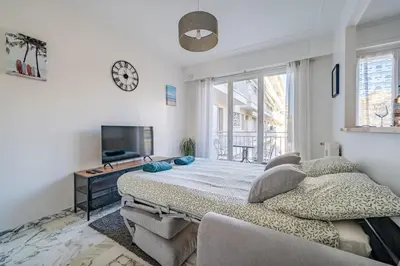 a bedroom with a large bed and a tv at Port de Nice - Studio with balcony in Nice