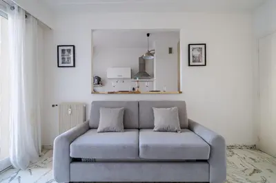 a gray couch in a living room with white walls at Port de Nice - Studio with balcony in Nice